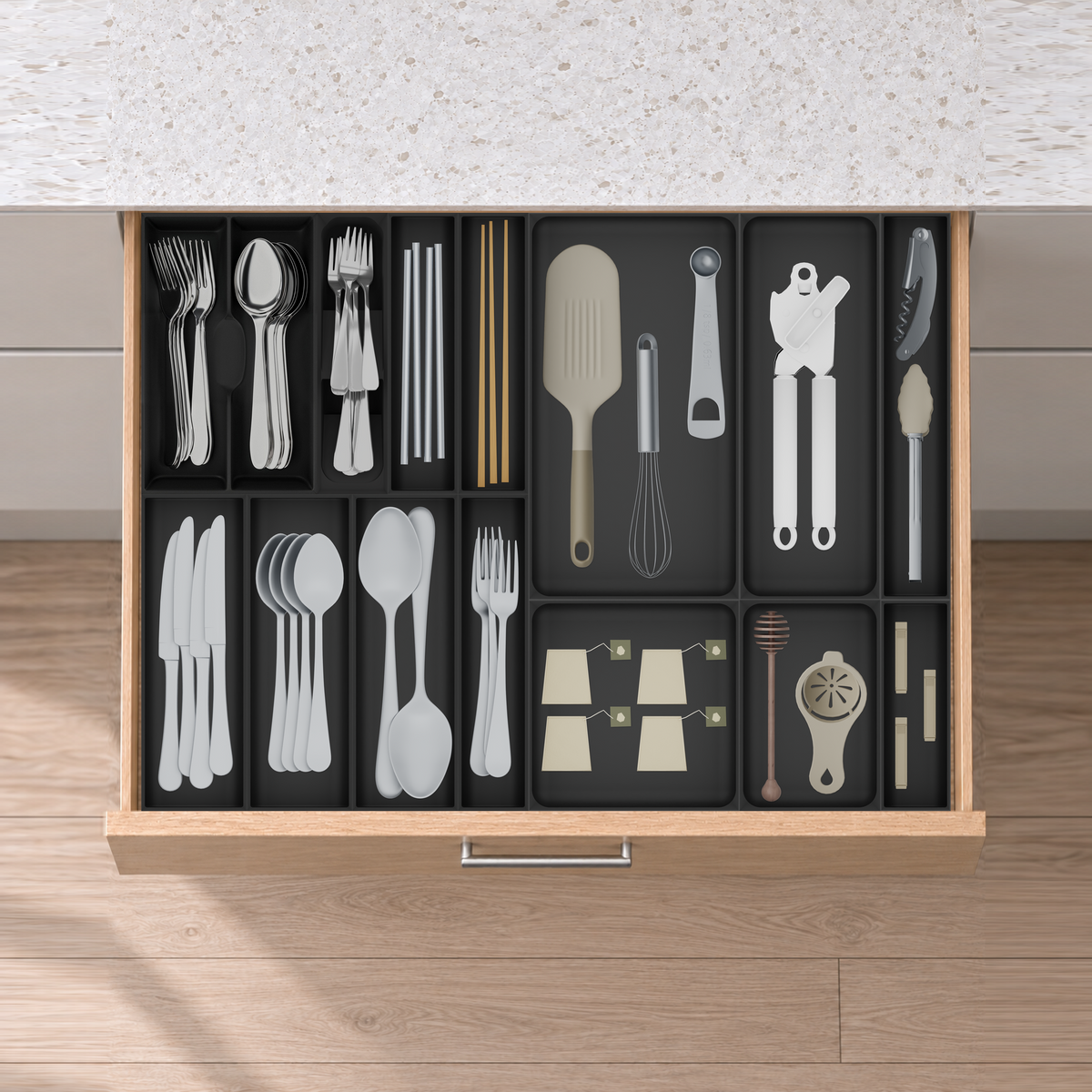 Wide Cutlery & Serving Tool Drawer Organiser Set in Charcoal Black, fitted in an oak drawer under neutral white light. Nominal layout 678.5 × 501.5 mm. Accessories shown are not included.