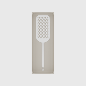 Long tray organiser – 11×4 (324.5 × 118 mm) in Muted White, shown with a handheld grater. Top view.